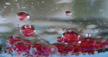 Bokeh emülsiyon balonu. Damlalar jel. Dipte tortu kırmızısı var. Sıvı hava yoğunluğunu farklı karıştırıyorum. Lavabo damlası. Kimyasal süreç yakın plan.