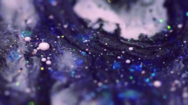 Yağ emülsiyonu. Parlak sıvı karışımı. Bulanık mavi mor renkli pırıl pırıl pullu pullu parçacıklar akrilik mürekkep akışkan hareketli soyut sanat arka planında Bokeh ışıkları.