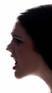 Dikey video. Arızalı sanat portresi. Sinir krizi. Gürültülü kızgın kadın beyaz arka planda iki kez izole edilmiş..