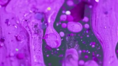 Köpüklü şeker. Parıldayan sıvı akışı. Odaklanmamış mor renk parıldayan tahıl tanecikleri yağ damlaları emülsiyon sıvı mürekkep dökülmesi hareket soyut sanat arka planı.