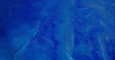 Islak mürekkep dokusu. Bulanık boya akışı. Mavi beyaz renk yanıp sönen sıvı parıldayan toz soyut sanat arkaplanında hareket ediyor..