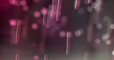 Görüntü düşüyor. Boncuk dağıtma etkisi. Hızlı hareket eden parçacıklar ışık noktalarıyla arka planı bokeh patlatırlar. Cam parlayan borular titreşen küçük tüpler..
