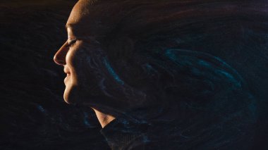 Evren silueti. Kozmik ilham. Profil çizelgesine göre, gece karanlığında parıldayan dumanlara gülümseyen, hayal kuran rahat kadın yüzü gökyüzü arka planında..