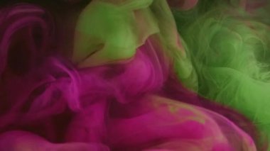 Su boyası. Artistik fırça. Güzel tasarım. Pigment su altında yavaş karışım hareketi. Modern sanatın soyut arka planında pembe yeşil renk karışımı.