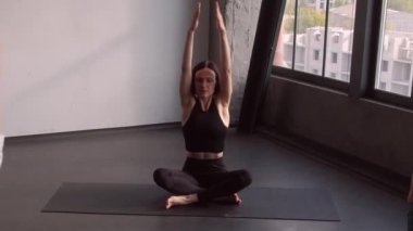 Pilates koçu. Fitness seansı. Nilüfer pozisyonunda oturan kadın spor eğitmenli aktif bir grup. Antrenman, amaste jesti, kapalı spor salonundaki sarılma..