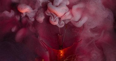 Çok renkli duman. Parıldayan bulut. Pembe boya akışının çözünürlüğü su yüzeyinde parlıyor. Kaotik sanat sıvısı fantezi patlama soyut arka plan.