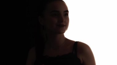 Dans eden siluet. Parti havası. Zarif, oynak, kaygısız bir kadının, beyaz, boş bir arka planda izole edilmiş neşeyle flört edişinin koyu kontrast çizgisi..