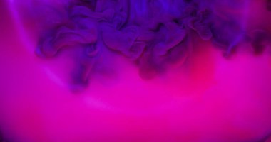 Duman patlaması. Yuvarlak mercek. Mor mürekkep lekesi parlak pembe sıvı yüzeyde yayılan neon fantezi. Çember kiriş ışığı soyut arka planı.