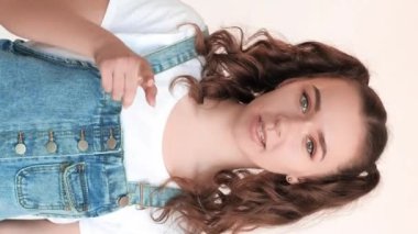 Dikey video. Kız vlogger yaşam tarzı. Motivasyon ilhamı. Hevesli, kendinden emin, cesaretlendirici, beyaz arka planda parmaklarını gösteren genç bir kadın..