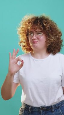 Dikey video. Tamam jest. Onay evet. Tatmin olmuş, gözlüklü tombul kız mavi üzerinde mükemmel el işareti gösteriyor..