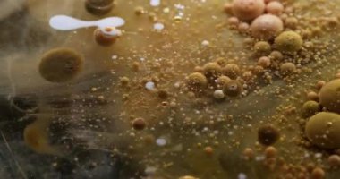 Kabarcık akışı. Akrilik kütle. Sarı kahverengi boya ile şeffaf doku sıvısı tüttürmek parçacıkların etrafında patlamış sanat tozu soyut arka plan.