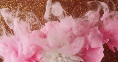 Suda çiçek boyamak. Renk dumanı. Pembe buhar, beyaz papatya yapraklarının üzerine su sıçratır altın parıltılı bokeh ışık dokusu soyut sanat arka planında..