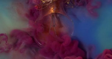 Akış patladı. Kırık cam. Pembe dumanlı dalgalı bulut bulanık sisli mavi yüzey üzerine dökülüyor su zarar görmüş ampul soyut arka plan.