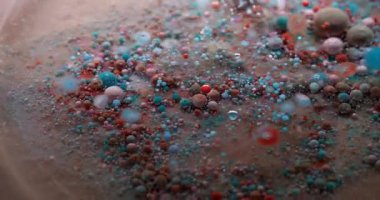 Köpüklü sis. Pigment dökülmüş. Küçük yuvarlak renk parçacıkları bulanık şeffaf sıvıda yüzen boyaları karıştırıyor. Petrol sanatı suyu soyut arkaplan.