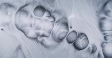 Mürekkep lekesi. Boyayı yayıyorum. Islak beyaz boya dokusu düz olmayan siyah yüzeyi doldurur. Sanat dumanı patlaması soyut arkaplanı eritiyor.