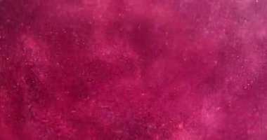 Işıldayan akış. Parlak sıvı. Odaklanmamış pembe renkli parlak toz parçacıkları su mürekkebi emülsiyon girdaplı soyut sanat arka planında titreşir.