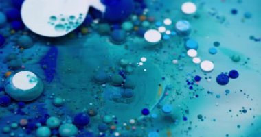 Boya akışı. Kabarcık emülsiyonu. Mistik mavi beyaz su karışımı çok renkli damlalar patlıyor. Dalga dökümü dokusu soyut arkaplan.