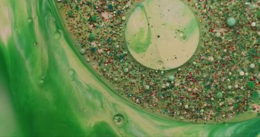 Akrilik kütle. Boya karışımı. Parıldayan metal parçacıkları yeşil suda yüzüyor. Soyut odaklanmış nem kabarcığı patlaması arkaplanı.