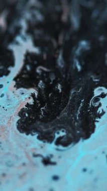 Dikey video. Mürekkep parlatıcı doku hareketi. Işıl ışıl mavi sıvı damlalar siyah turuncu boya dalgaları titreşen emülsiyon soyut arka planda akar.