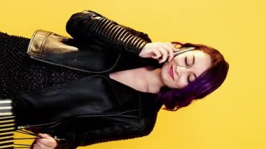 Dikey video. Alışverişe çağırıyorlar. Kara Cuma. Kendine güveni olan, kağıt çantalı, sarı renkli telefondan konuşan, kendine güvenen kadın..