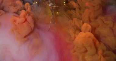 Parlak duman. Sanat sıvısı. Parlak renkli arka planda turuncu boya şişmesi. Dalgalı karışım bulut parçacıkları kırık lamba.