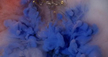 Mürekkep akışı. Boya çözülüyor. Soyut arkaplan ampulü üzerinde parlak renk akışları çakışır. Süt gibi köpüklü suda canlı mavi bulut.