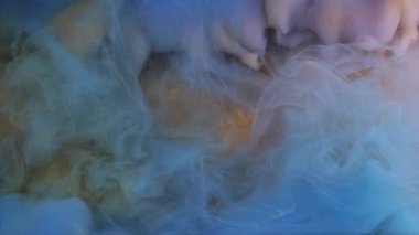 Lüks duman. Kozmik boya uçuyor. Odaklanmamış mavi renkli bulut desenli soyut altın sanat arkaplanına mürekkep dokusu sıçratır.