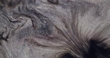 Işıldayan yayılma. Lüks boya. Kıymetli sıvı toz gümüş gri sanat yüzey parçacıkları dökülür. Soyut birleştirme akışları kara delik bulanık arkaplan.