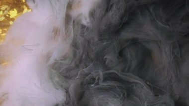 Bulut dumanı. Boya mürekkebi. Odaklanmamış gri renkli duman bulutu, soyut altın desenli arka plan üzerine sis dokusu sıçratıyor.