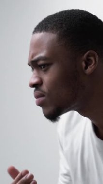 Dikey video. Deri sorunu. Sivilce tedavisi. Alerji tahrişi. Sinirli, tatminsiz, rahatsız bir adam aynada kuru bir yüze dokunuyor..