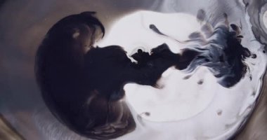 Grunge akışı. Siyah mürekkep. Koyu pigmentlerin kıvrımlı beyaz yüzey dokusu. Suyun soyut arka planında dumanlı mistik bukleler karışır.