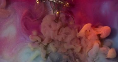 Parıltılı akış. Boya patladı. Çok renkli duman kıvrımları garip bir şekilde ışıl ışıl sanat sıvısı arka planlarını karıştırıyor. Peçe dumanı pembe su ampulü kırıldı..