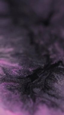 Dikey video. Renk karışımı. Işıltılı sıvı hareketi. Pembe siyah boya yavaşça akar desen sıvı karışım dalga soyut inci arkaplan.