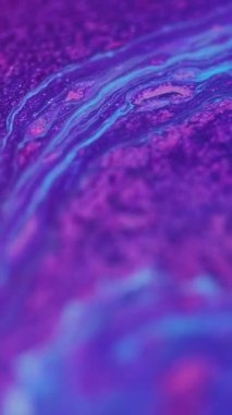 Dikey video. Akrilik sıvı. Parıltı emülsiyonu. Boya mavi mürekkep neon mor renkli parıldayan parçacıklar yaratıcı soyut arkaplan tasarımı.