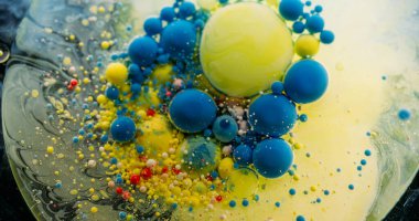 Boya damlası. Akrilik baloncuk. Yuvarlak pigment çok renkli topların katmanlı daire yüzeyini karıştır. Sanat sıvısı mavi sarı parçacıklar soyut arkaplanı eritiyor.