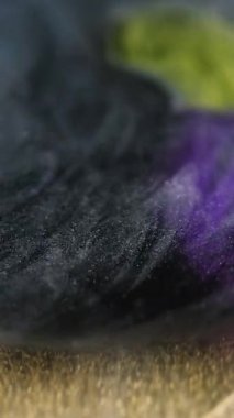 Dikey video. Mürekkep boyası. Odaklanamayan pigment akışı. Işıl ışıl altın dokular ışıl ışıl emülsiyon ile doldurulmuş siyah sarı renk eklentileri soyut arkaplan.