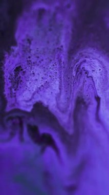 Dikey video. Işıl ışıl parlıyor. Işıldayan doku. Mor boya sıvısı hareketli arka plan siyah emülsiyon büyüleyici soyut sanatta yayılır.