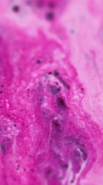 Dikey video. Mermer mürekkep. Boya akışı. Parlak parıltı. Odaklanmamış pembe beyaz renk parıltılı sıvı sızıntısı büyüleyici kozmetik sıvısı ışkan parçacıklar hareketli soyut sanat arka planı.