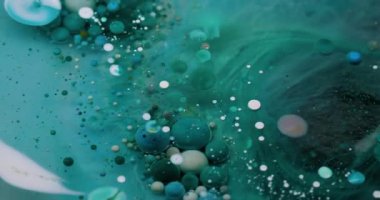 Köpüklü sis. Pigment dökülmüş. Yuvarlak turkuaz mavi parçacıklar bulanık şeffaf sıvıda boya dökülmesini karıştırıyor. Petrol sanatı suyu soyut arkaplan.