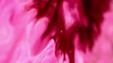 Islak sim sıçraması. Işıl ışıl. Odaklanmamış morumsu pembe renk parıldayan mermer desenli boya soyut sanat arkaplanı yayıyor..