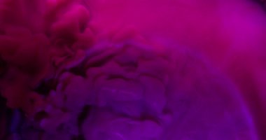 Sanat sıvısı. Duman boyası. Mor pembe parıltı dalgası sıvı karışımı neon rengi ışıltılı arka plan su bulanık spot ışığı lensi.