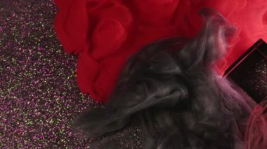 Dumanı karıştırıyorum. Duman boyası. Siyah kırmızı sis bulutları parlak soyut arka planda cam küple birlikte akıyor. Zıt titreşimli çözünürlükte suda bulanık boya..