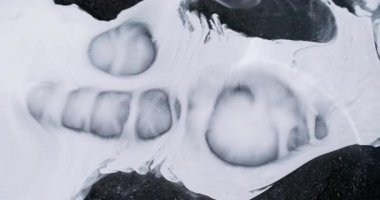 Enamel akışı. Beyaz sıvı. Hafif sanat eseri mürekkep sıvısı dağınık parçacıklar siyah tepe yüzeyine yayılır. Yaratıcı soyut arkaplan monokrom peçesi.
