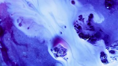 Mürekkep sızıntısı. Parlayan akıntı. İki püskürtücü mor sıvı boya renkli parlak yüzeyin üzerine dökülmüş. Suluboya çözünmüş parlak düzensiz dokunun üzerine dökülüyor.