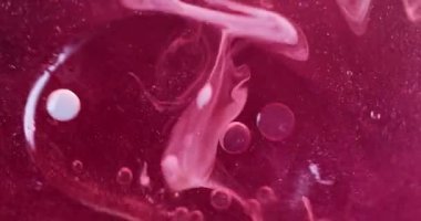 Sanat sıvısı. Kabarcık emülsiyonu. Pembe, beyaz, pırıl pırıl parlayan boya, bulanık duman dokusu, akrilik yağ damlası, soyut arka planda yüzüyor..