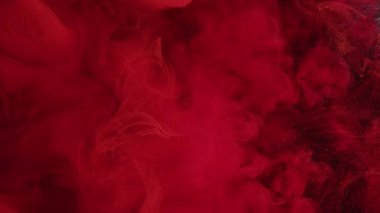 Mistik boya. Kırmızı sis. Sis rengi bulanıklık ve soyut bir arka plan. Parlak mürekkep suda çözülür. Küçük parçacıklarla karışır..