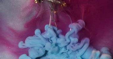 Dumanlı boya. Işıl ışıl. Pembe gümüş metalin arka planında patlayan mavi sisli duman. Soyut parlayan ampul yüzeyi.