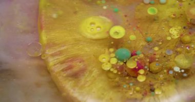 Parıltı akıyor. Kabarcık patladı. Renkli pırıl pırıl altın sıvısı ve yuvarlak jel dökülmüş. Sarı pembe leke parlak su soyut arkaplan.
