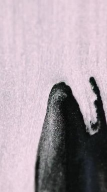 Dikey video. Gümüş boya akışı. Parlak mürekkep. Bulanık beyaz siyah renk. Parlak sıvı damlalar. Işıl ışıl şelale parçacıkları..
