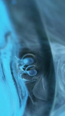 Dikey video. Mürekkep suyu. Sis boyası. Odaklanmamış gri renk dökülmüş metalik parlak sıvı, mistik dumanlı karışım jel emülsiyon soyut sanat arka planı..